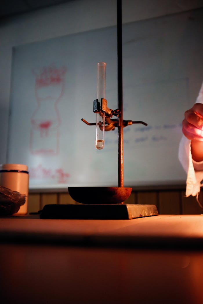 Close-up of a test tube and stand in a dimly lit laboratory, showcasing experimental setup.